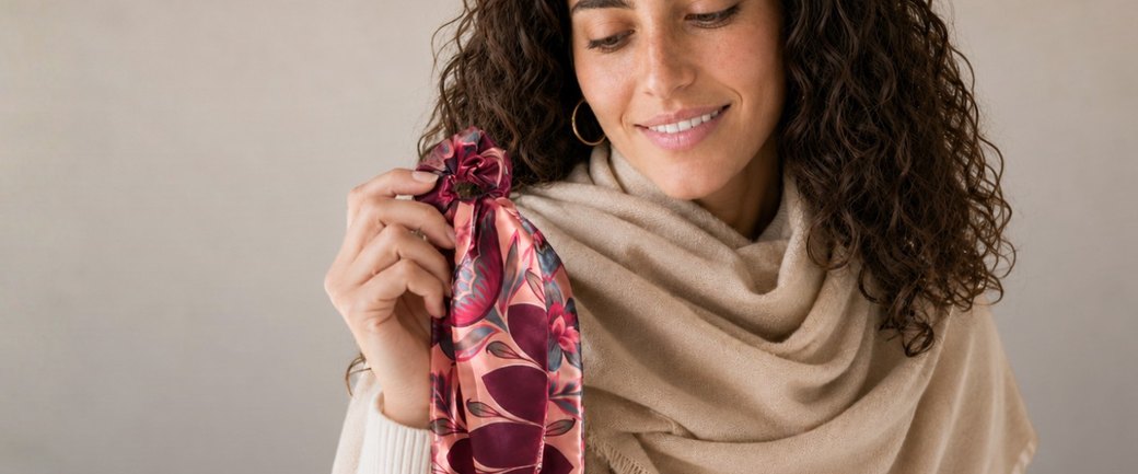 Modelo con pañuelo Scarfme y scrunchie de seda en la mano